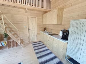 aneks kuchenny i schody na antresole w domku z jasnym drewnem