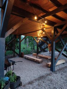 strefa chill ze stołem i ławkami zrobionymi z drewna pod domkiem